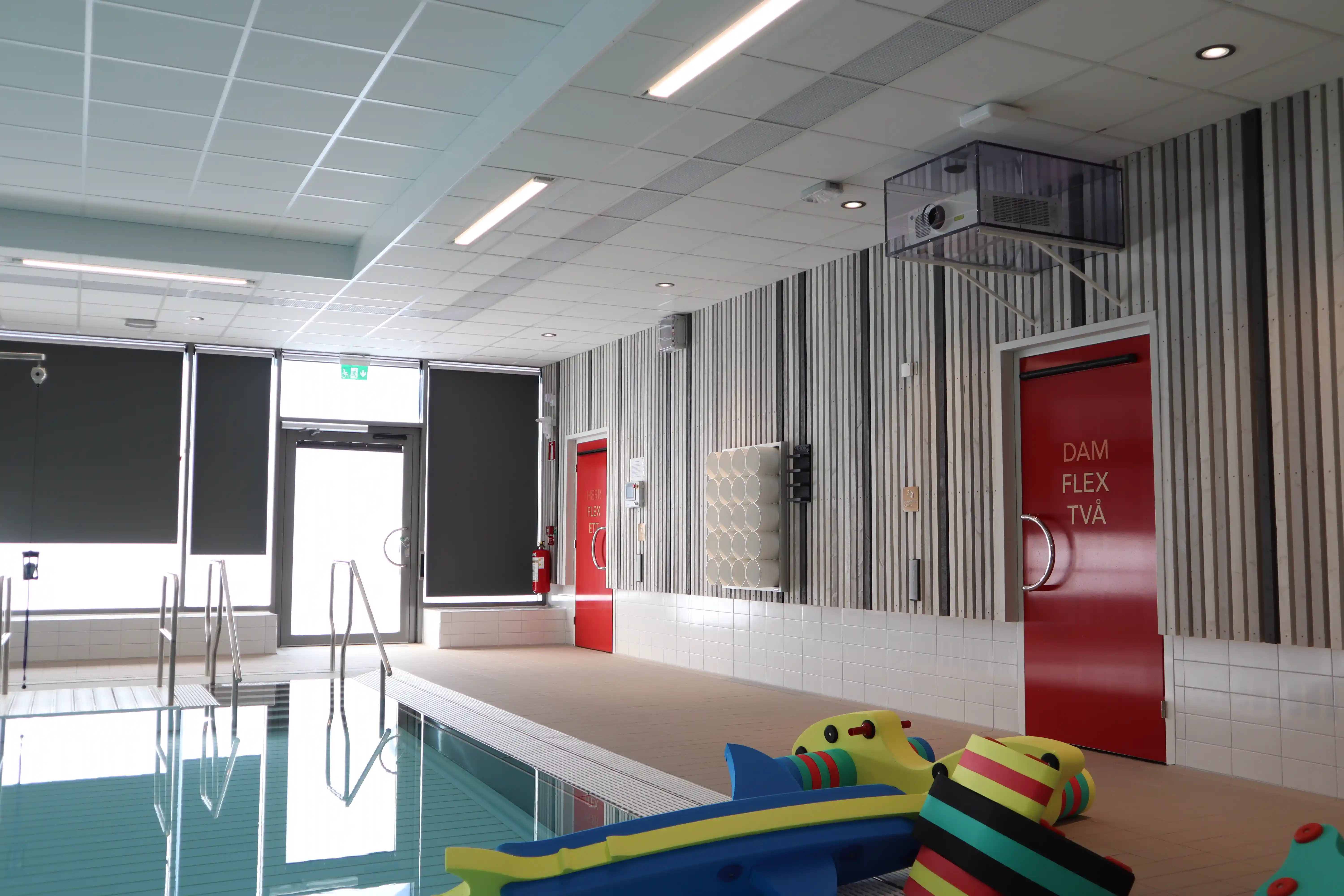 Projektor monterad högt på väggen vid multibassängen i Säffle simhall
