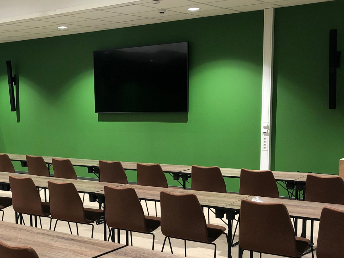 Konferensrum i Hundfjällscenter med stor skärm och pelarhögtalare